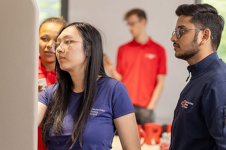 Imagebild von einem Workshop in dem mehrere Personen an einem Whiteboard stehen und arbeiten.